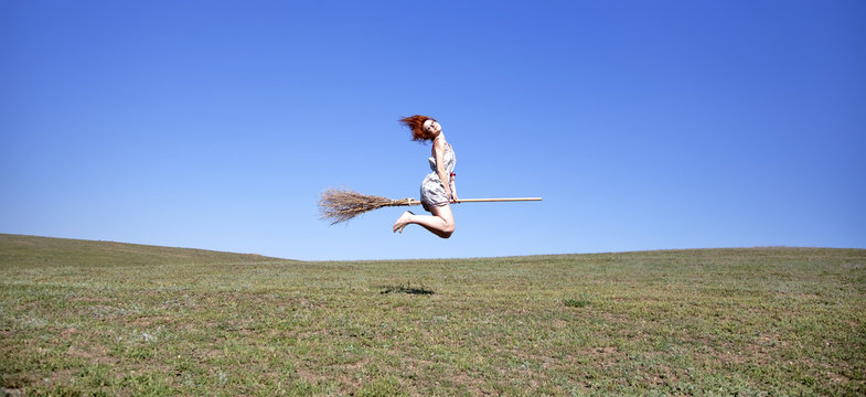young witch flying over field