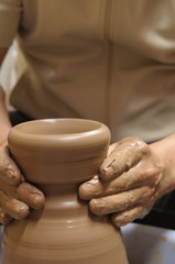 Fototapeta na wymiar Potter at work. Artist shaping a bowl on a pottery wheel