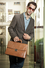 Fototapeta premium Confident young businessman holding a briefcase