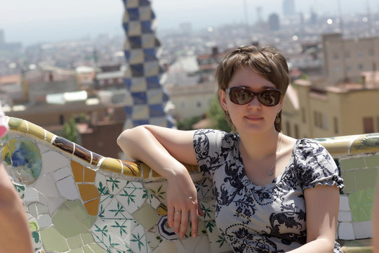 Girl sits on bench at park Guell