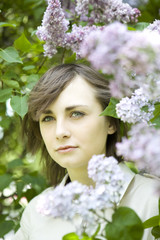 Fototapeta premium smiling brunnete woman standing nearby lilac.