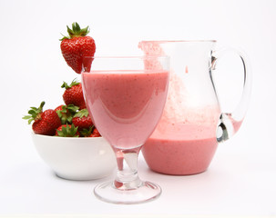 Strawberry shake in a glass and a jug,strawberries in a bowl