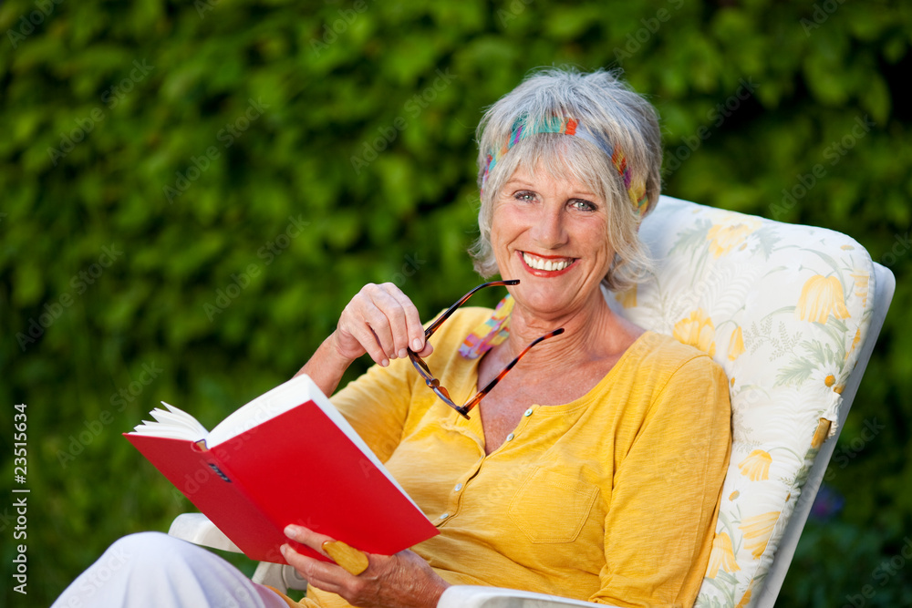 Poster ältere dame mit buch im garten