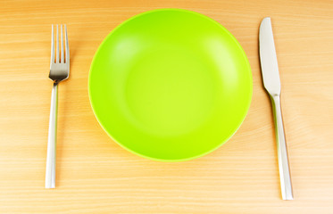 Plate with utensils on wooden table
