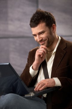 Happy guy smiling with laptop