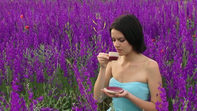 Woman drinking tea in the field
