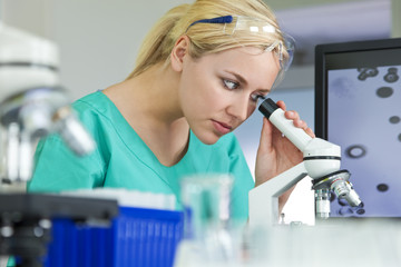 Female Scientist or Woman Doctor Using Microscope In Laboratory