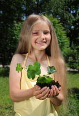 Little girl holding a seedling in cupped hands