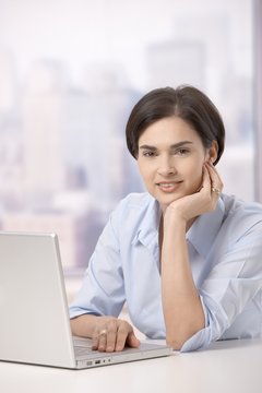 Portrait of smiling woman with computer