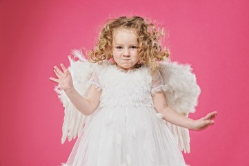 Beautiful little angel girl isolated on pink background