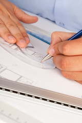 Architect working on architectural plans in the office