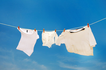 T-shirt drying on clothesline on a hot summer day .