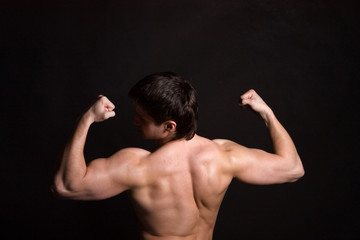 Fototapeta na wymiar Back of sexy muscular man, isolated on black