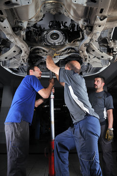 Auto mechanics working under the car - a series of MECHANIC