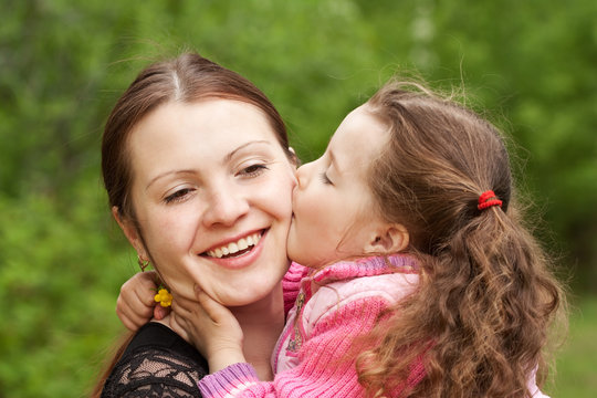 The small daughter kisses mum