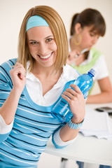 Fototapeta premium Student at home - smiling woman with bottle of water