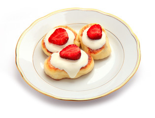 Cheese cakes decorated with strawberries on plate
