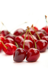 Ripe red cherries on white background, vertical view