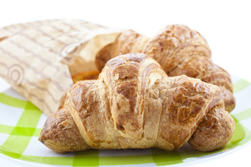 croissants in paper pack on plate isolated