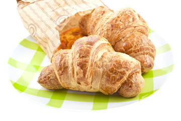 croissants in paper pack on plate isolated