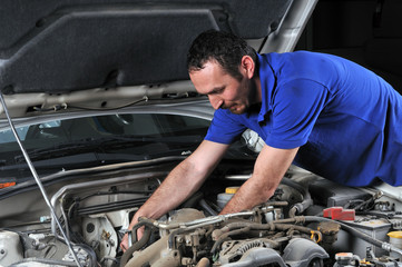 Auto mechanic working on car engine - a series of MECHANIC