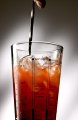 Shaker filled with ice cubes and redish liquid