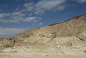 Scenic view of a mountain range against blue cloudy sky.