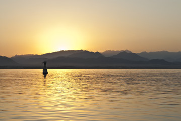 Naklejka na ściany i meble Sunset over the Sinai desert, seen from the sea.