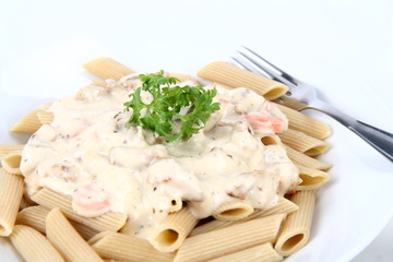 Penne with white sauce on a plate decorated with parsley