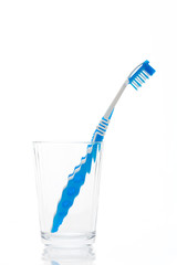 A blue toothbrush in glass isolated on a white background