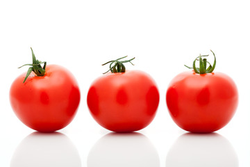 Three fresh tomatoes isolated on a white background