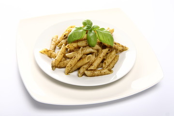 Penne with pesto decorated with basil on a plate