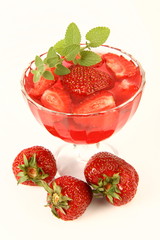Red gelatin dessert with lemon balm twig and strawberries