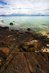 Tropical stones beach under blue sky. Thailand