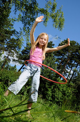Little girl having fun with hula hoop