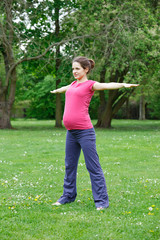 Beautiful pregnant woman exercising in the park