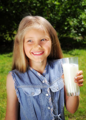 Little happy girl drinking milk