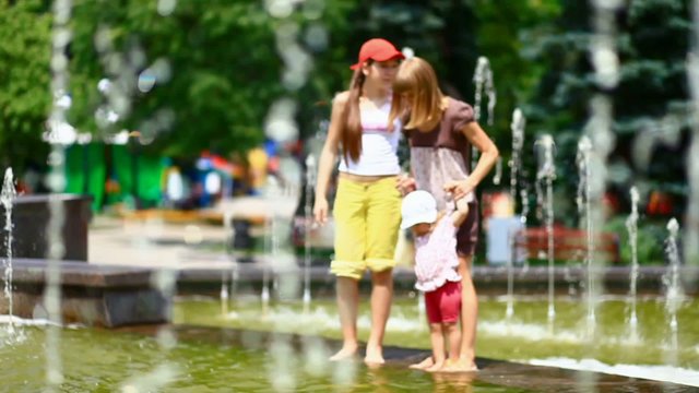 Mother and child in a fountain in a park in FullHD