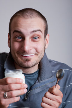 ragazzo felice mangia yogurt con faccia buffa