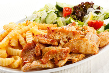 Grilled meat with fried potatoes and vegetables