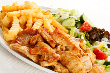 Grilled meat with fried potatoes and vegetables