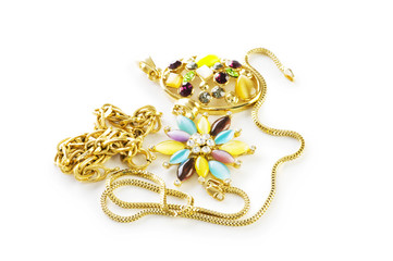 Golden chain and brooch isolated on white