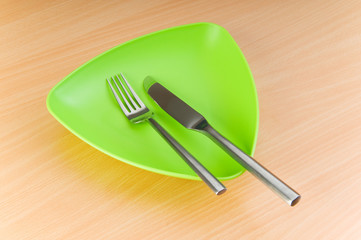 Plate with utensils on wooden table