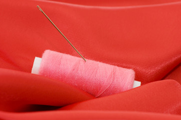 Ball of threads on a red fabric