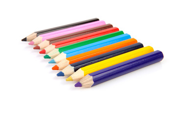 colorful pencils in a row over white background