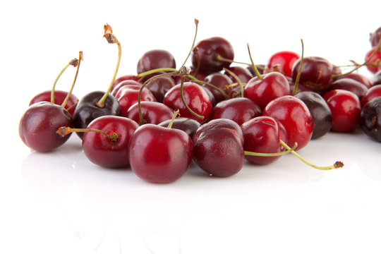 fresh cherries in closeup over white background