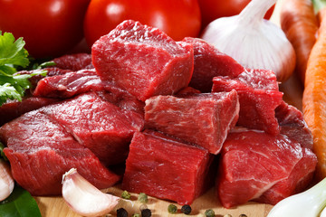 Raw beef on cutting board and vegetables