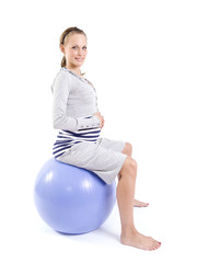 Young pregnant woman exercising with fitness ball