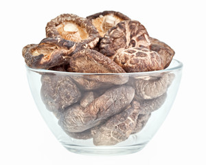 Dried field mushrooms in a glass bowl isolated on white