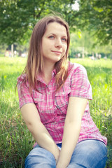 young girl in a park in a pose sitting